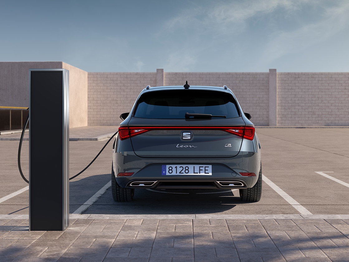 Bakifrånvy av seat leon sportstourer för automatisk billaddning på en station, en ny hatchback för 2025 imagnetgrått, komplett med bakre parkeringssensorer och LED-strålkastare och bakljus.