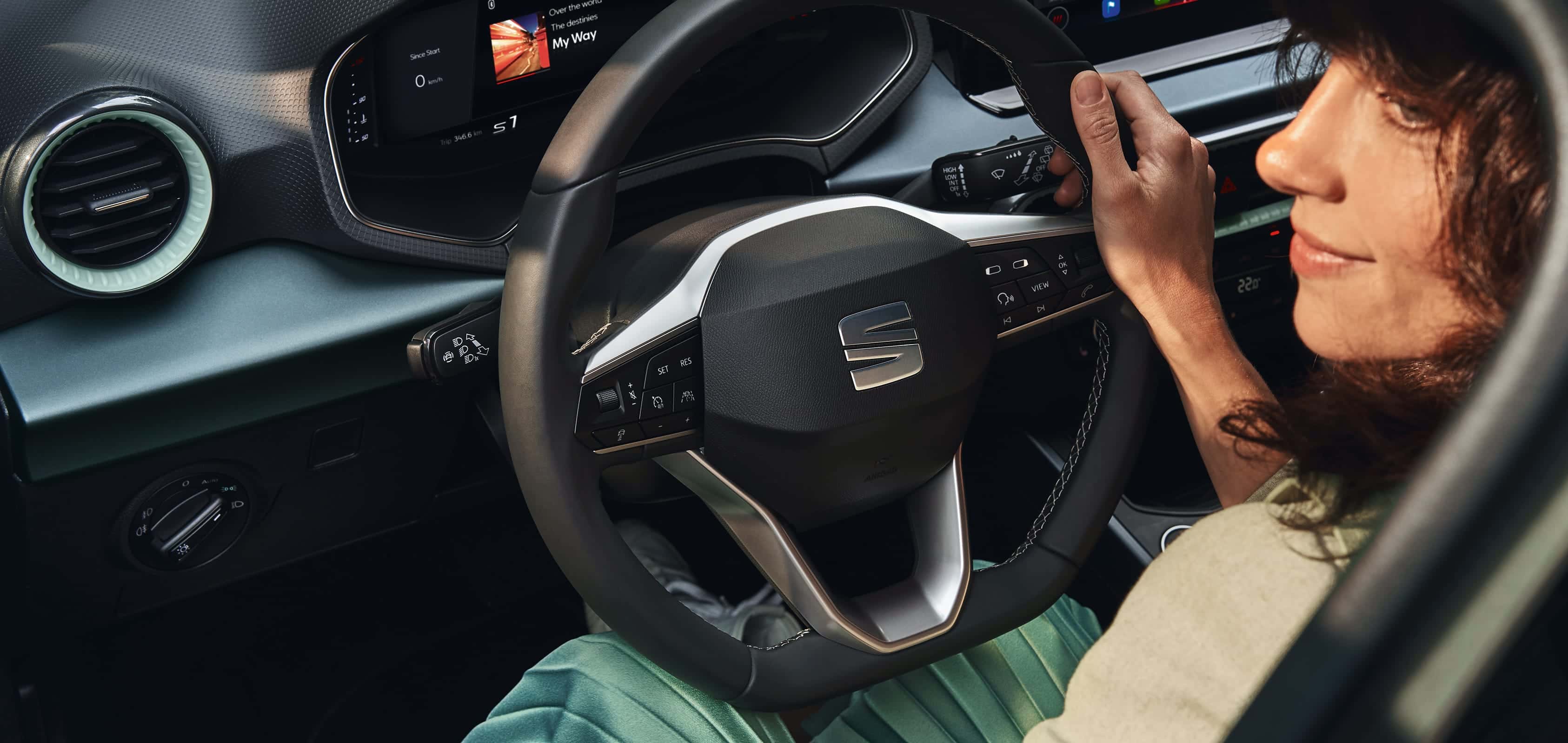 Kvinna som går fram till en SEAT Arona i färgen dark camouflage 