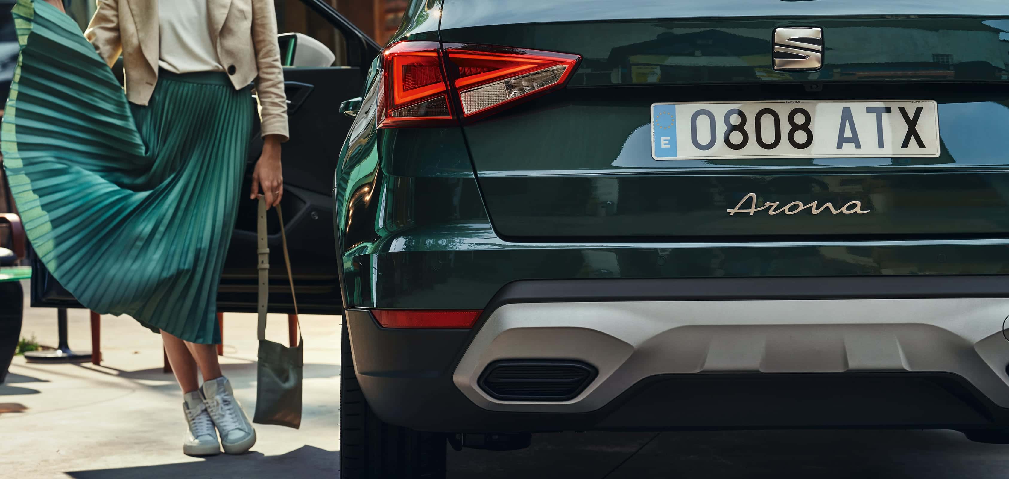 Seat Arona i färgen dark camouflage med tak i candy white sedd bakifrån   