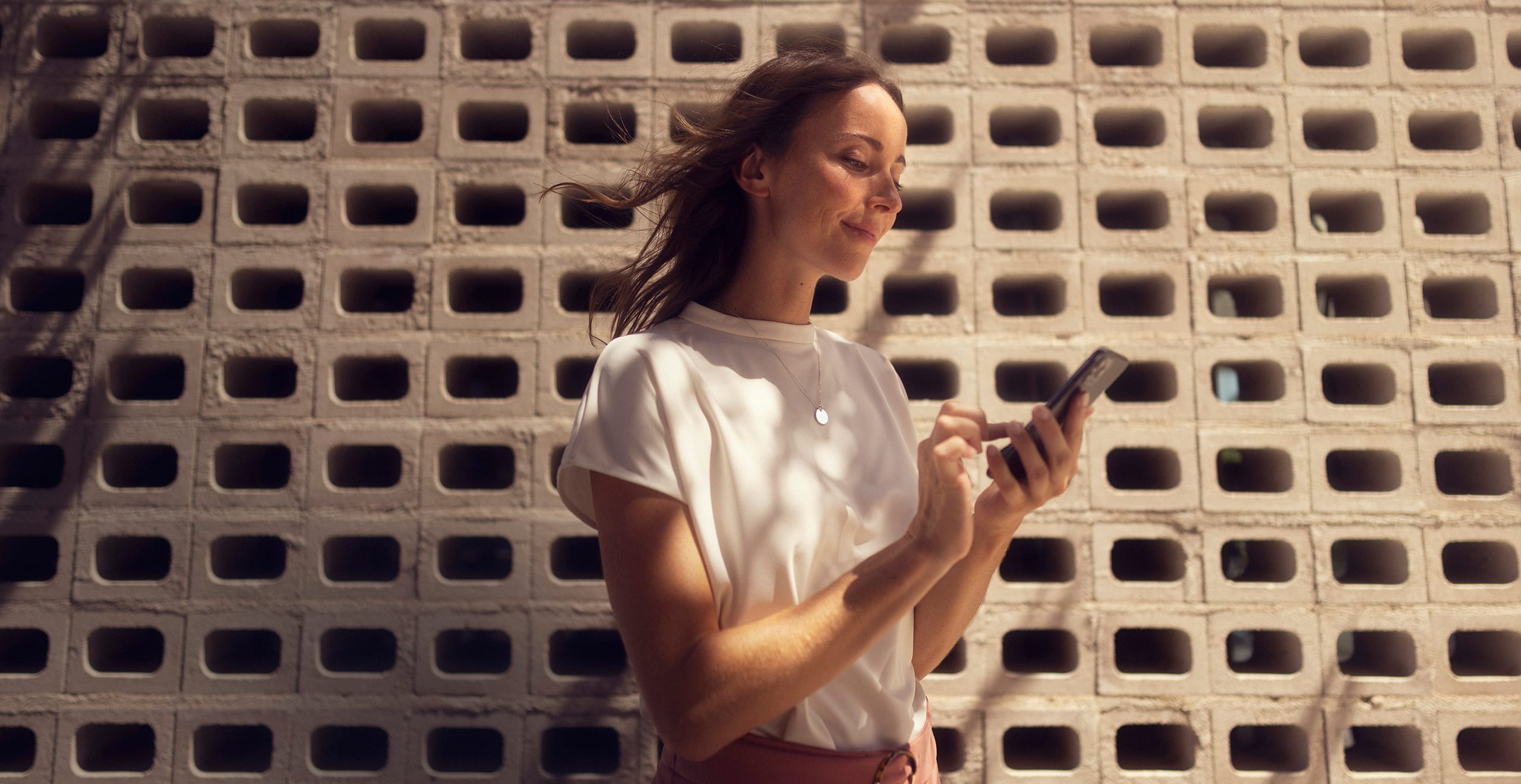 Kvinna som har sin smartphone uppkopplad till SEAT CONNECT
