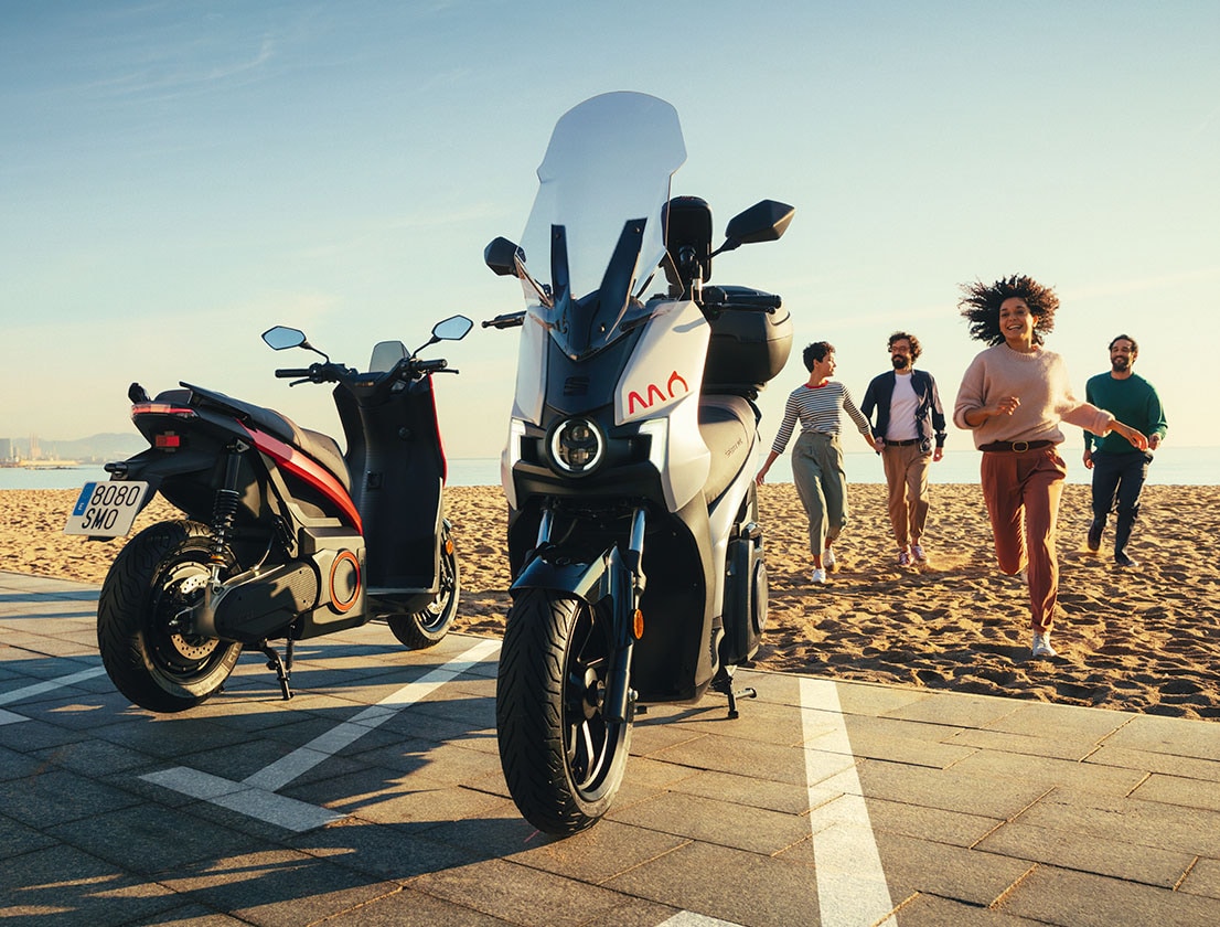 People running to a SEAT MÓ 125 electric scooter for navigating the city with zero emissions