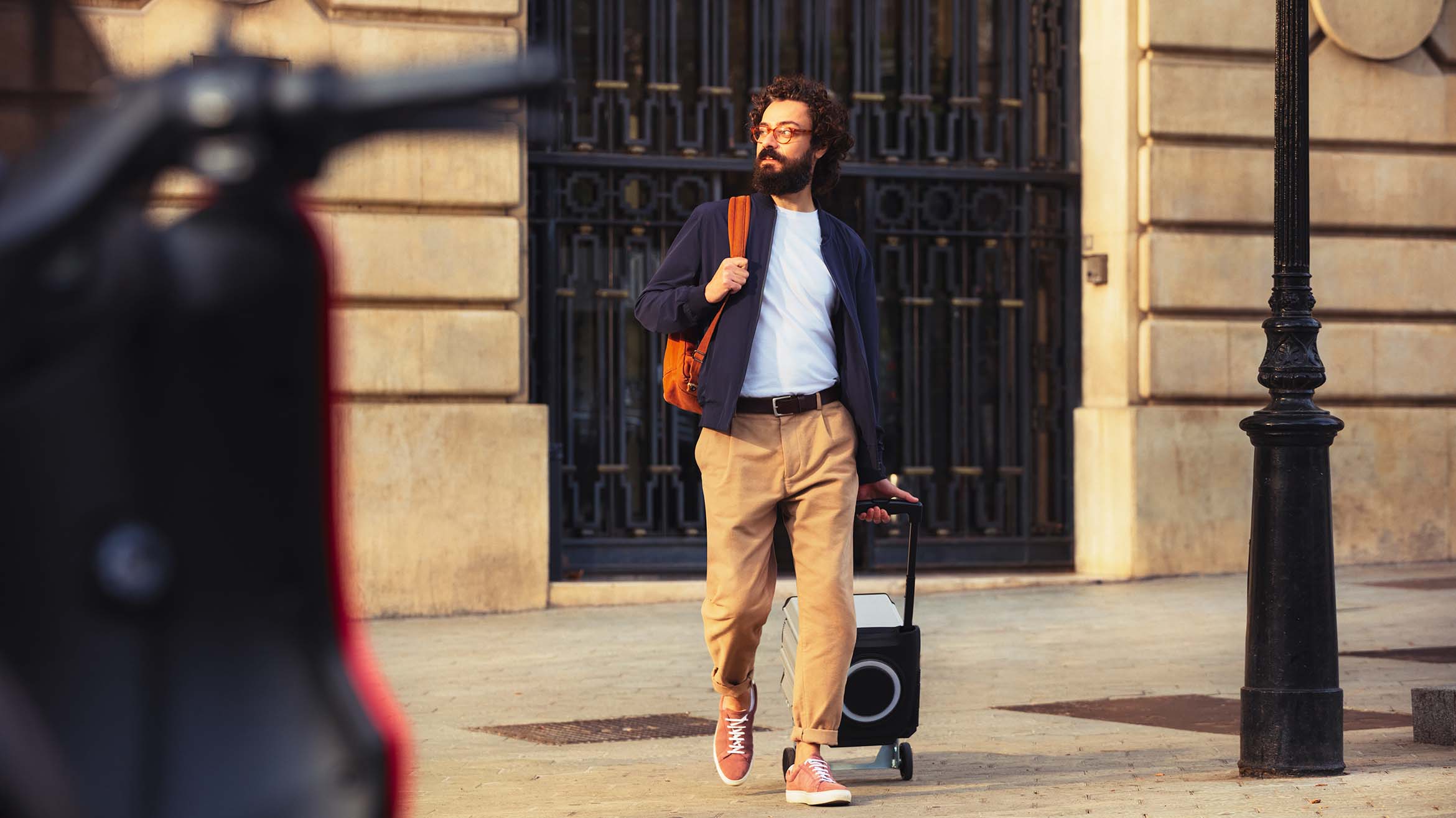 person walking towards their SEAT MÓ 125 electric scooter parked in the city