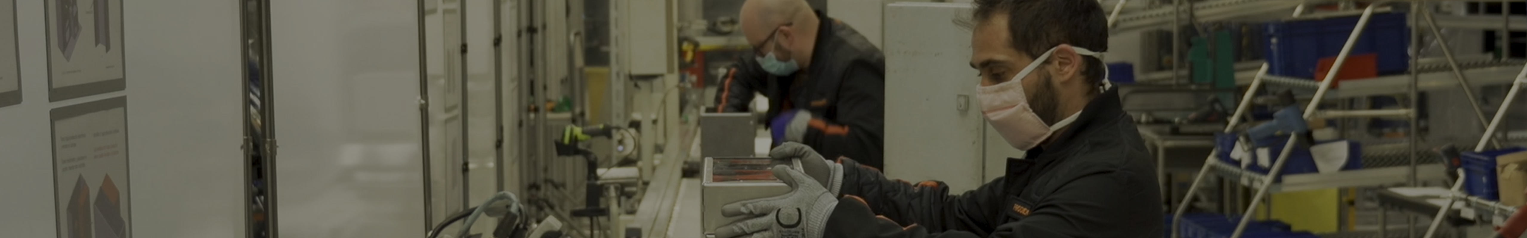 Arbetare med munskydd i SEAT-fabrik, som inspekterar bildelar