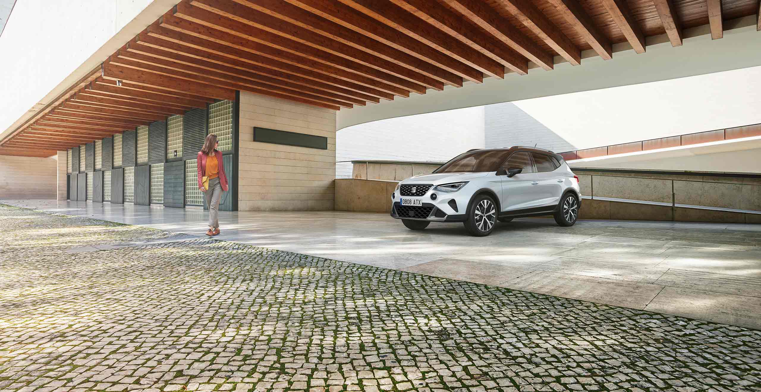 Woman looking at SEAT Arona candy white colour with black roof 