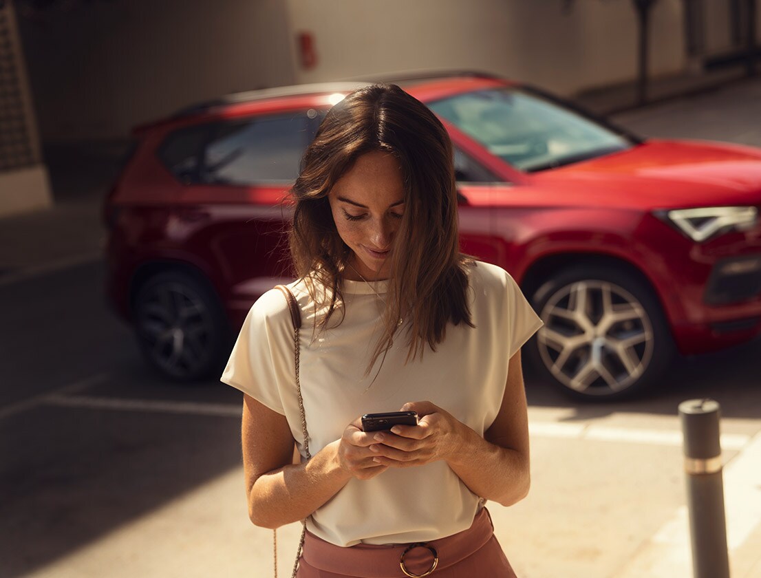 kvinna-som-anvander-seat-connect-app-med-sin-smartphone