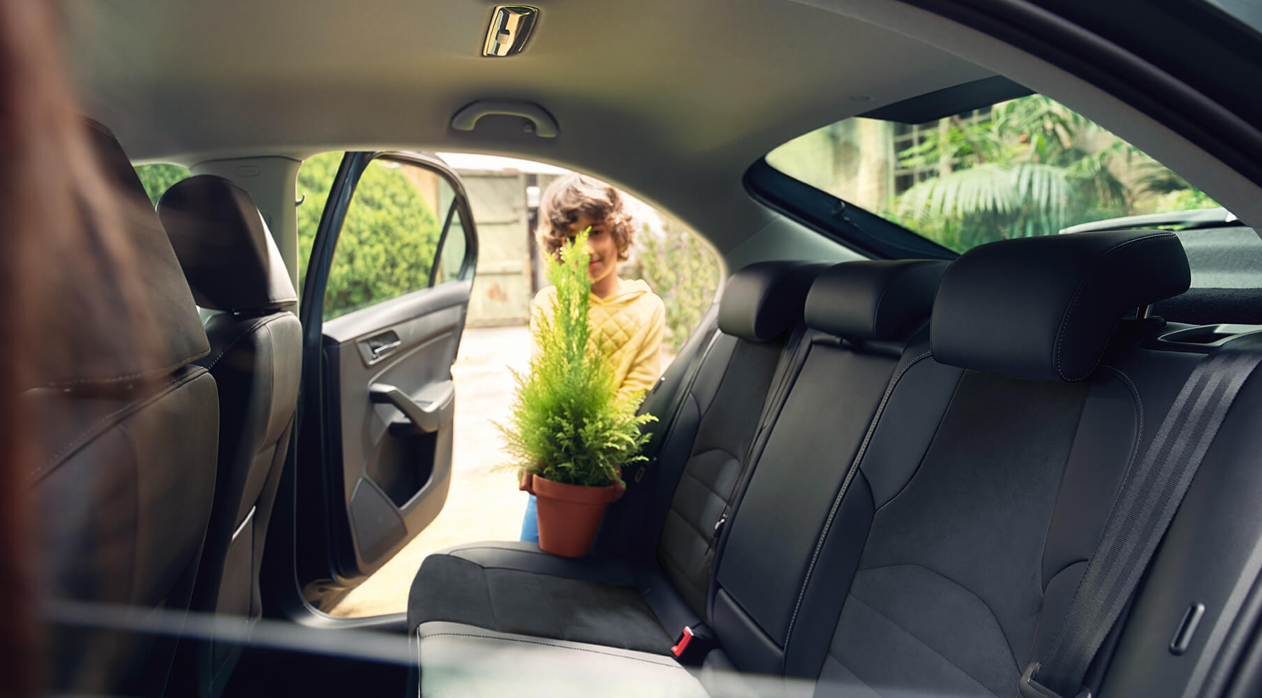 SEAT service och underhåll för nya bilar uttjänta fordon – Pojke som placerar en växt i baksätet på en ny bil