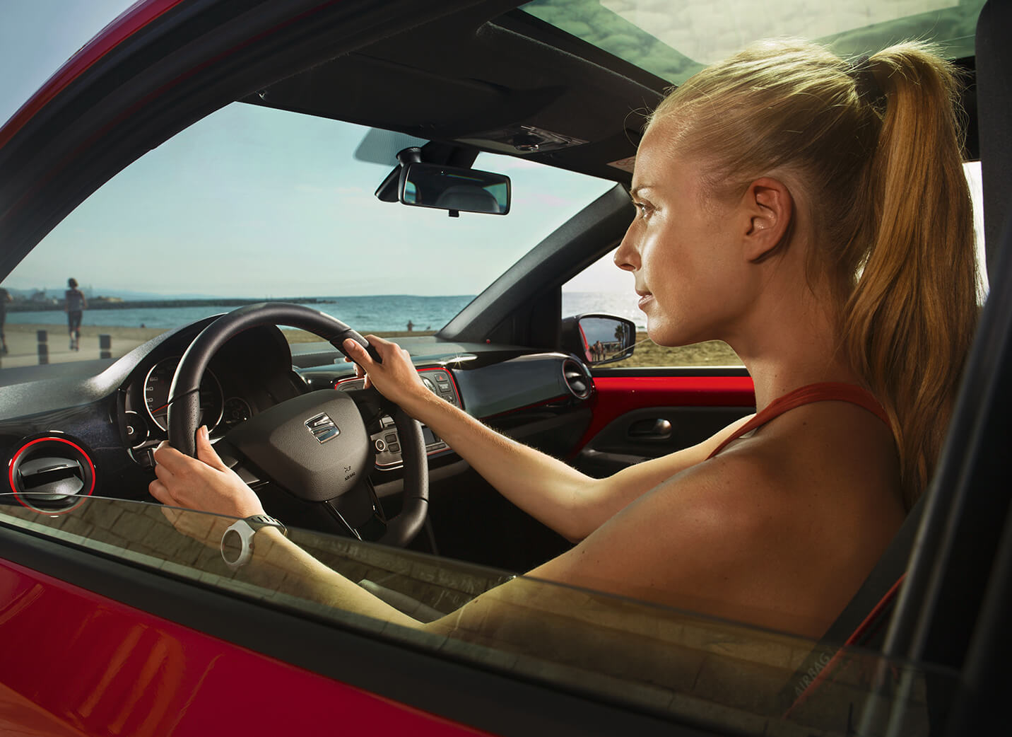 SEAT service och underhåll för nya bilar – Sidovy över kvinna som kör en röd, ny SEAT-bil